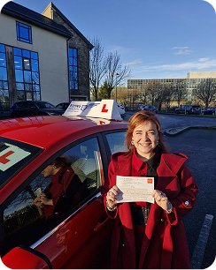 Young woman smiling proudly outdoors on a bright day, holding a certificate, excited expression-14